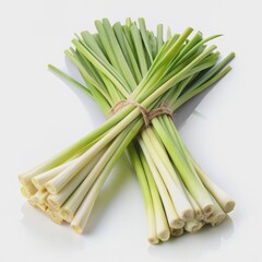 Obraz premium Vibrant fresh lemongrass leaves with delicate white edges and citrusy aroma laid flat on a pure white background, ideal for cooking and wellness themes.