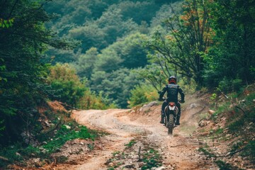 a man riding an off-road motorcycle motocross or enduro motorcycle on a mountain road in a green forest