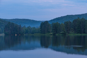 Setting sun low light long exposure over mountain lake summer season background image