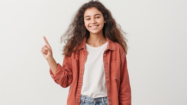 A woman with long hair is wearing a red jacket and pointing to the sky. She is smiling and she is happy