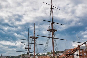 Tall ship masts with rigging against a cloudy sky in Whitby, North Yorkshire