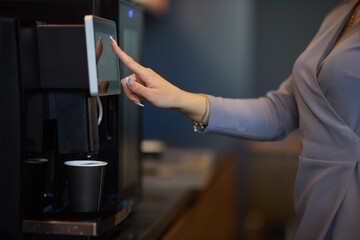 Professional using a touchscreen coffee machine for a convenient coffee break at work
