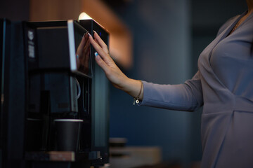 Professional using a touchscreen coffee machine for a convenient coffee break at work