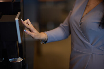 Professional using a touchscreen coffee machine for a convenient coffee break at work