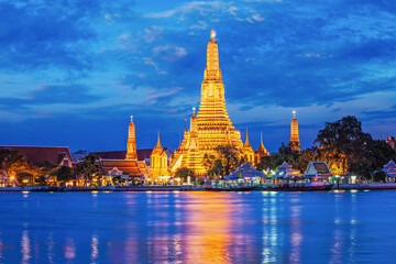 Naklejka premium Buddhist temple Wat Arun (Wat Arun Ratchawararam Ratchawaramahawihan - Temple of Dawn) famous tourist landmark illuminated in the evening. Bangkok, Thailand