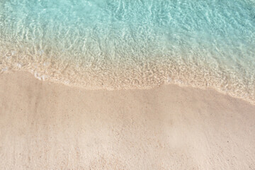 Sea waves rolling on beautiful sandy beach, top view. Summer vacation