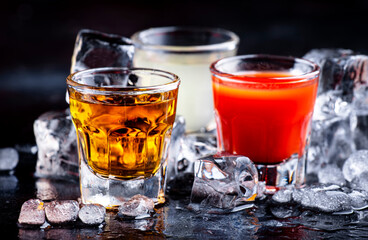 Golden tequila, sangrita and fresh lime juice on ice. Black background