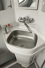 Stainless steel washbasin in train car restroom