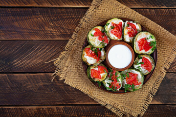 Fried zucchini with sour cream sauce, tomatoes and greens