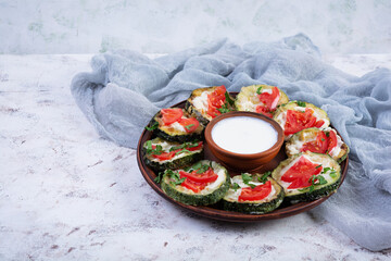 Fried zucchini with sour cream sauce, tomatoes and greens