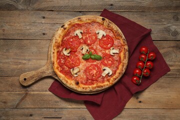 Delicious pizza with tomatoes, mushrooms and basil on wooden table, flat lay