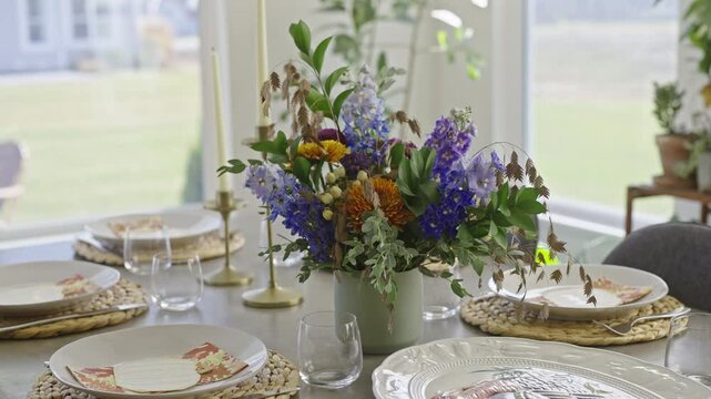 Flower bouquet in the center of a set table for dinner.