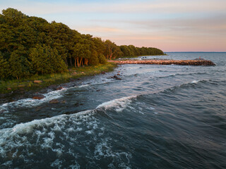 A breakwater and forest coastline in the Baltic Sea, Leesi area. Estonian landscape. Summer photo from a drone.