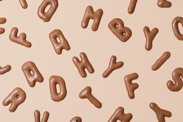 Pattern of alphabet biscuits on a beige background