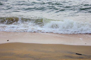 A serene capture of gentle waves washing up on the sandy shores of Pantai Teluk Lipat Dungun, Terengganu.