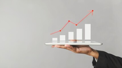 Hand holding tablet with growth graph and upward arrow increasing sales performance, technology and business growth, data analysis