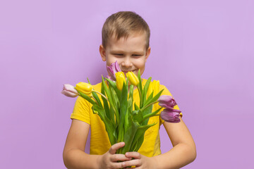 little boy with a bouquet of tulips on a purple background. Portrait. Happy maretry day.