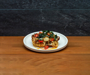 Roasted Cauliflower Steak with cherry tomato and coriander served in dish isolated on wooden table side view of italian fastfood