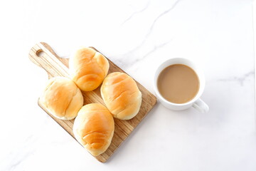 焼きたてで熱々のバターロールと、淹れたてのカフェ・オ・レが用意された朝食のテーブル
