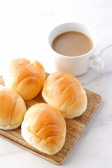 焼きたてで熱々のバターロールと、淹れたてのカフェ・オ・レが用意された朝食のテーブル
