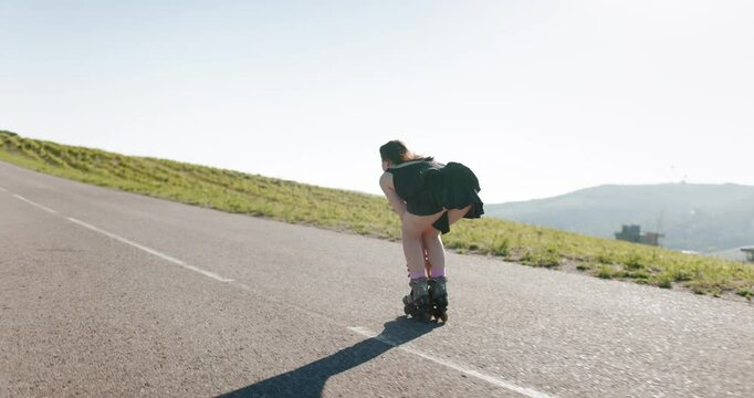 Sporty woman riding on roller skates outdoor on sunny day