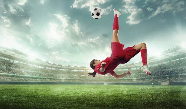 Female soccer player in red performs bicycle kick on stadium field. Stadium with spectators. Cinematic shot. Victory. Concept of sport, championship, action, team game, tournament. Ad - Powered by Adobe