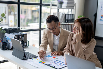 Two people are sitting at a desk looking at a presentation