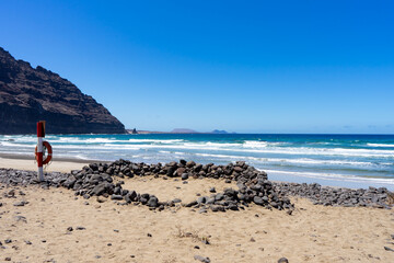 Rettungsring am Strand mit Felsen auf Lanzarote