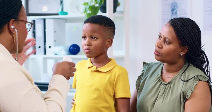 Young Boy In Consultation With Doctor And Mother