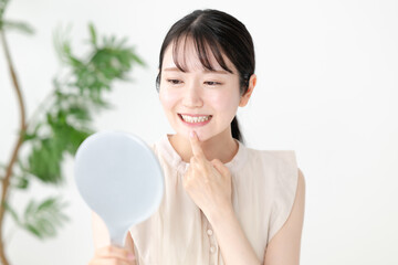 手鏡で歯を確認する女性