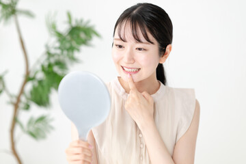 手鏡で歯のチェックをする女性
