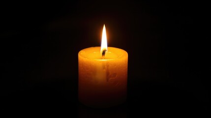 Lit candle in the darkness, flame glowing brightly, creating a serene atmosphere