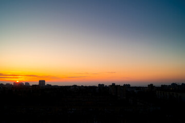 Half of the Rising Sun in the Clear Sky over the City