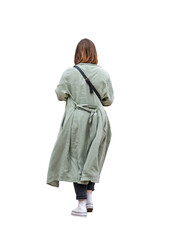 Jeune femme vue de dos portant un long manteau vert, regardant son téléphone portable en...
