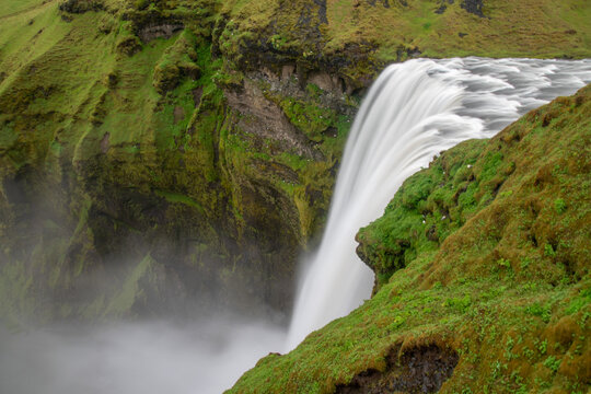 Top view long exposurere of Skogafoss with birds nesting around