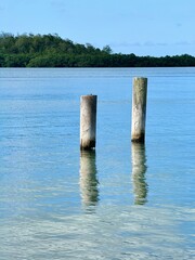 peaceful seascape of Guadeloupe in the French West Indies with a view of wooden posts in an arm of...