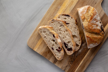 Homemade Bread with Kalamata Olives on a wooden board, top view. Copy space.