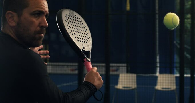 Super slow motion close up of paddle player is hitting ball during competition game match or training workout on indoor court at 1000 fps.