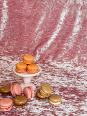 Macarons, cute gluten free dessert cookies on a luxurious pink velvet background