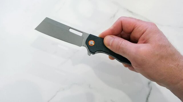 Introducing an EDC knife for everyday carry. D2 steel blade, sheepfoot or cleaver shape, micarta handle. Opening, presentation and closing. The background is marbled white.