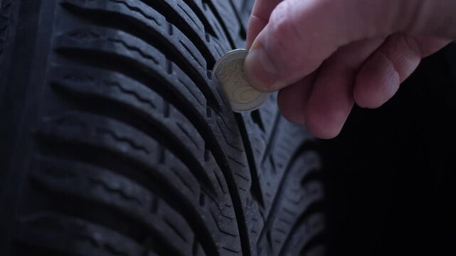 Coin check on tire tread for safety. Close up.