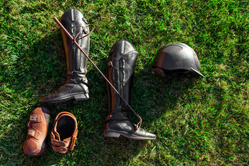 flat lay shot of equestrian horse riding equipment with helmet, leather boots, gloves and stick on...