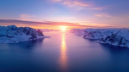 Naklejka premium Stunning Arctic sunrise over a tranquil sea surrounded by snow-covered mountains. The vibrant sky reflects beautifully on the calm water.
