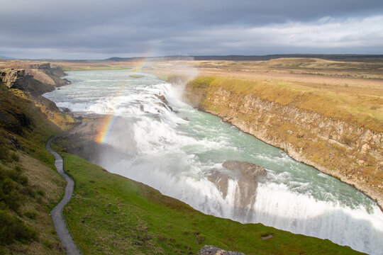 A partial rainbow over the gushing Gullfoss waterfall in Iceland
