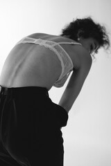 A girl puts on panties and underwear, beautiful delicate black white fashion photograph on a white background. A woman in lingerie and panties, a woman with beautiful hands