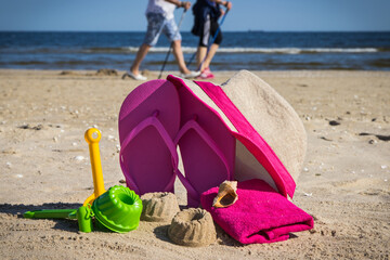 Accessories and children toys for playing or relax on sand at beach. Straw hat, flip flop and...
