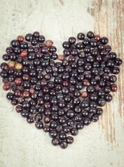 Heart shape made of fresh elderberry containing vitamins and minerals. Healthy nutrition, natural...