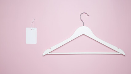 Creative flat lay hangers with white paper label. Clothing tag, label blank mockup template. Sale discount store promo shopping concept. Top view. Copy space