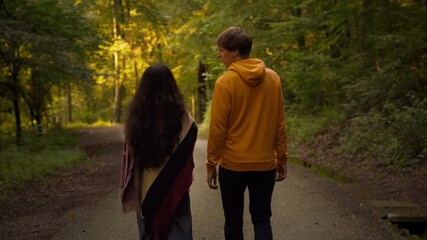 Two friends or a couple talking and enjoying a relaxed walk in nature. Lifestyle slow motion follow shot
 - Powered by Adobe