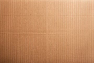 Close-up view of a textured brown cardboard surface, perfect for background or packaging themed projects. Neutral and ecologically friendly material.